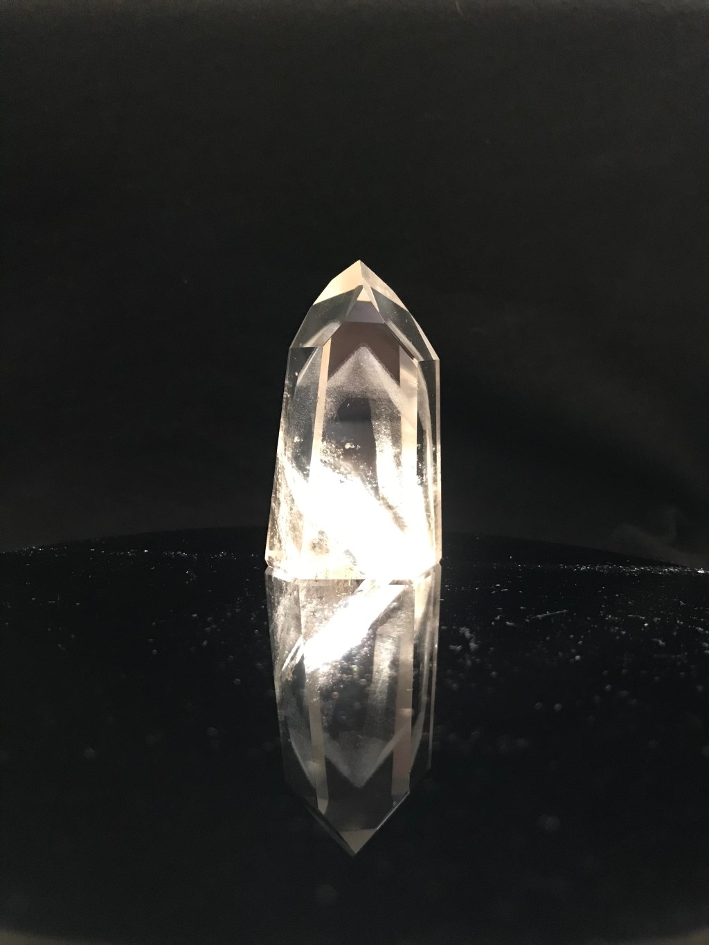 Clear quartz crystal with phantom on black background